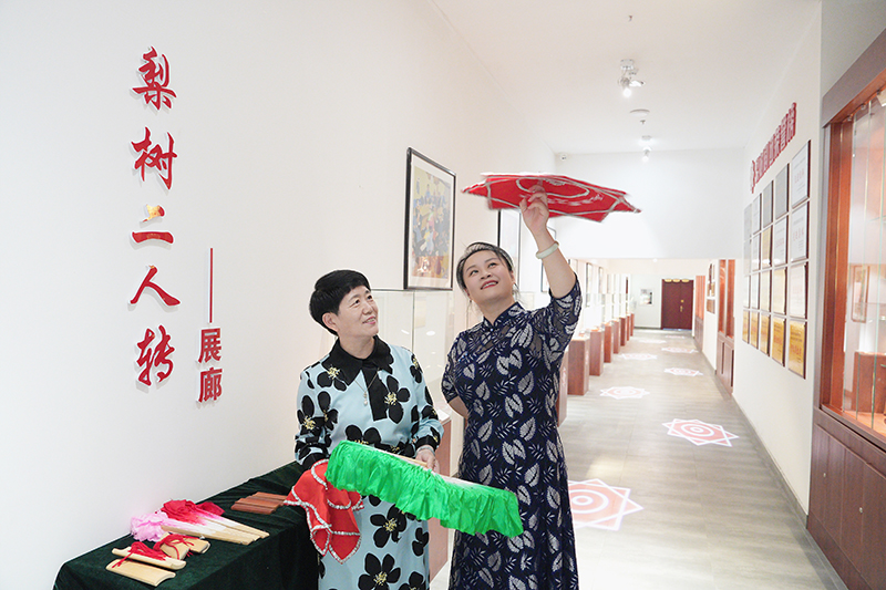 2023年6月29日，在吉林省梨樹縣地方戲曲劇團梨樹二人轉(zhuǎn)展廊，團長趙丹丹（右一）為作家龔保華講解二人轉(zhuǎn)技巧。