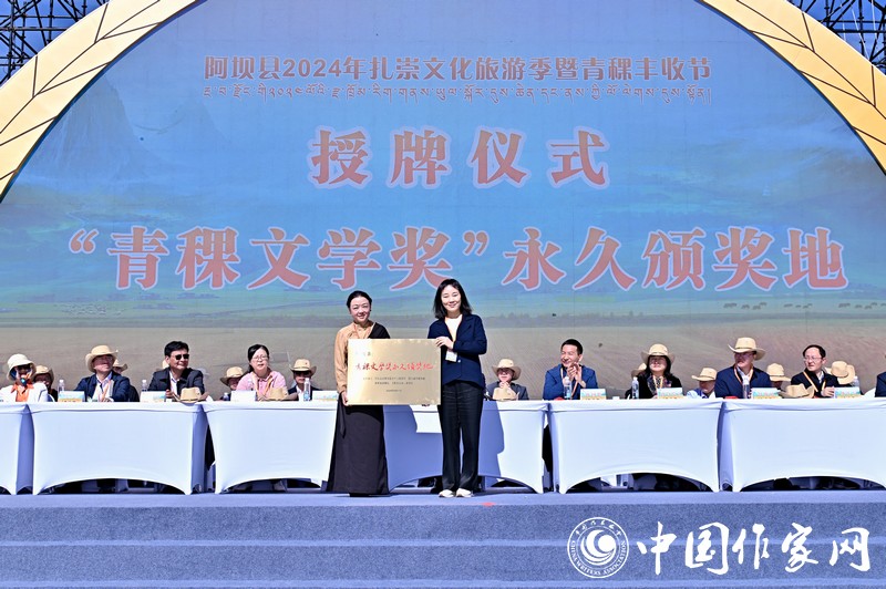 陳亞軍主編代表《民族文學(xué)》向阿壩縣授牌，紅梅部長接牌。